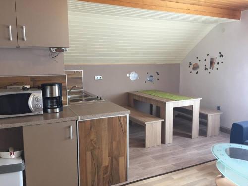 eine kleine Küche mit einem Tisch und einer Mikrowelle in der Unterkunft Fewo Linda 2 in Gunzenhausen