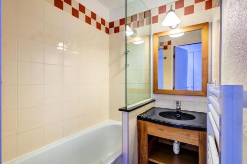 une salle de bain avec un lavabo, une baignoire et un miroir dans l'établissement Résidence Les Constellations - maeva Home - 2 pièces 7 personnes Selection MAE-0489, à La Plagne Tarentaise