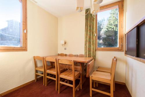 une salle à manger avec une table et des chaises et une fenêtre dans l'établissement Quartier La Forêt - maeva Home - Appartement 3 pièces 8 personnes Confort MAE-1181, à Valmorel
