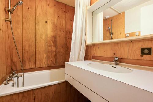 een badkamer met een wastafel, een bad en een spiegel bij Les Résidences de Valmorel - maeva Home - Appartement 3 pièces 8 personnes 81 in Valmorel