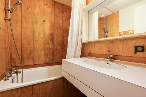 une salle de bain avec un lavabo, une baignoire et un miroir dans l'établissement Quartier La Forêt - maeva Home - Appartement 3 pièces 8 personnes Confort MAE-1181, à Valmorel