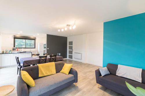 ein Wohnzimmer mit 2 Sofas und einer Küche in der Unterkunft Chambres D'hôte Le Cèdre Bleu in Saint-Jean