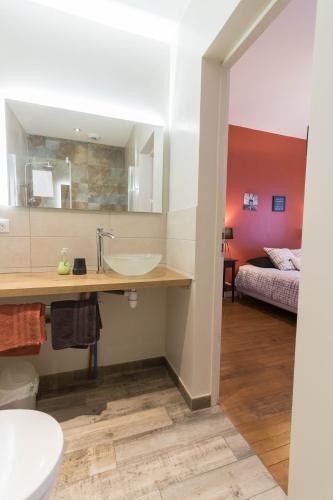 La salle de bains est pourvue d'un lavabo et d'un lit dans la chambre. dans l'établissement Chambres D'hôte Le Cèdre Bleu, à Saint-Jean