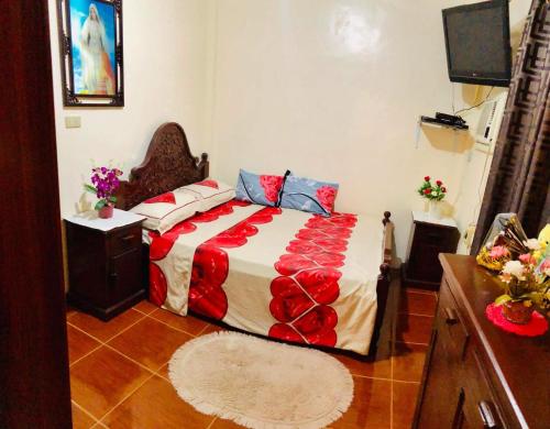 a bedroom with a bed with a red and white blanket at 15pax-U2-Rose&Fer Vigan Transient-Near Calle Crisologo in Bantay