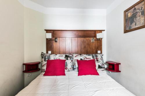 une chambre avec un lit avec deux oreillers rouges dans l'établissement Résidence Le Mont Soleil - maeva Home - Appartement 2 pièces 4 personnes Confort MAE-2057, à Mâcot La Plagne
