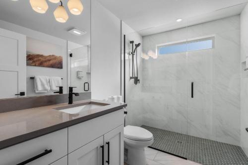 a white bathroom with a toilet and a shower at OBRILEY in Bend