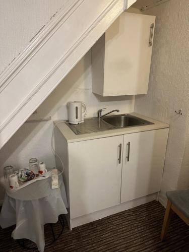 a small kitchen with a sink and a counter top at Sandpiper Guest House in Brighton & Hove