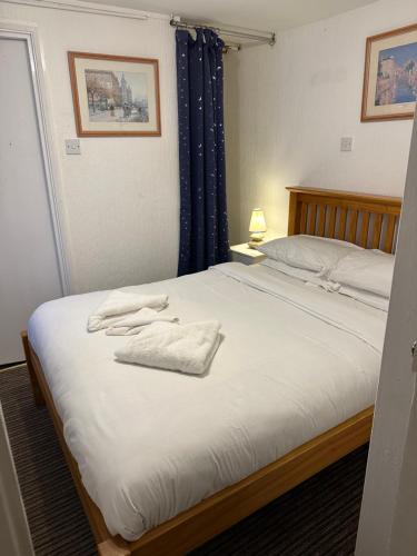 a bedroom with a bed with towels on it at Sandpiper Guest House in Brighton & Hove