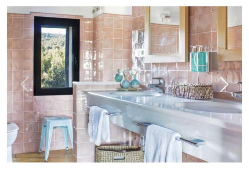 ein Badezimmer mit zwei Waschbecken und einem blauen Stuhl in der Unterkunft MasQi, The Energy House in Banyeres de Mariola