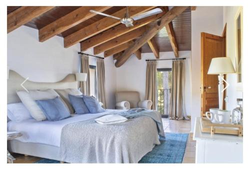 een slaapkamer met een groot bed met blauwe kussens bij MasQi, The Energy House in Bañeres de Mariola