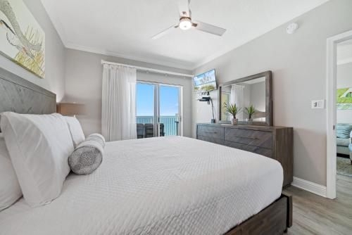 a bedroom with a white bed and a mirror at Crystal Shores Unit 1405 in Gulf Shores