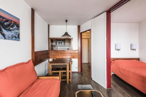 Cette chambre comprend un lit, une table et une cuisine. dans l'établissement L'Aiguille - maeva Home - Appartement 2 pièces 5 personnes Confort MAE-2197, à Chamonix-Mont-Blanc