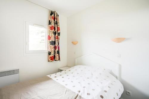 um quarto branco com uma cama e uma janela em Résidence Le Thabor - maeva Home - Appartement 2 pièces 5 personnes Confort 66 em Le Désert