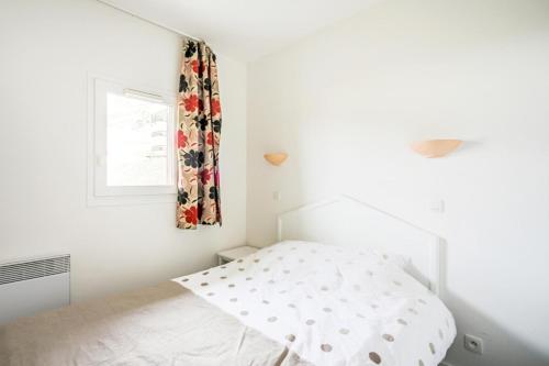 une chambre blanche avec un lit et une fenêtre dans l'établissement Résidence Le Thabor - maeva Home - Appartement 2 pièces 5 personnes Confort MAE-2466, à Le Désert