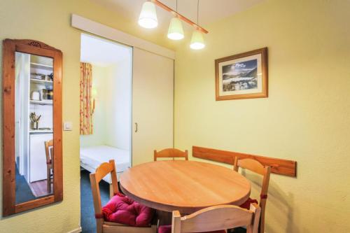 une salle à manger avec une table et des chaises en bois dans l'établissement Résidence Les Horizons d'Huez - maeva Home - Appartement 2 pièces 4 personnes Sélection MAE-3559, à Huez