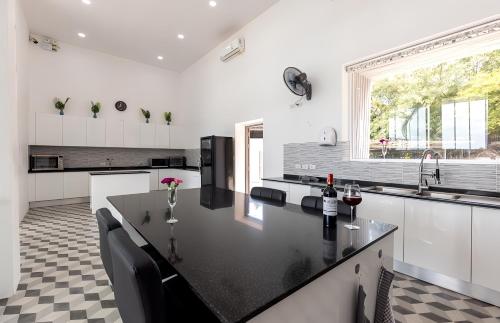 a kitchen with a black counter top and a window at Blue Elephant Villa Koh Phangan in Haad Pleayleam