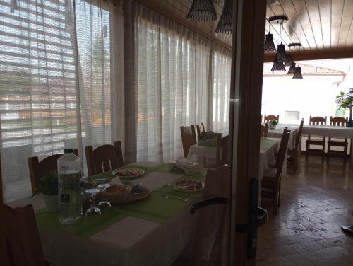 a dining room with a table and chairs and windows at Pestele Ca Odinioară in Murighiol