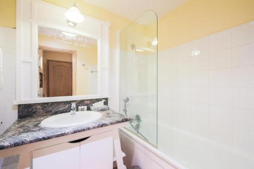 une salle de bain avec un lavabo, une douche et un miroir dans l'établissement Résidence Les Arcs 1950 Le Village - maeva Home - Appartement 2 pièces 4 personnes Sélection MAE-3657, à Bourg-Saint-Maurice