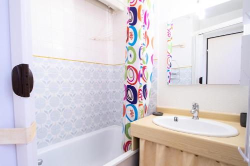 ein Bad mit einem Waschbecken und einem Duschvorhang in der Unterkunft Résidence Les Portes De La Vanoise - 2 Pièces pour 6 Personnes 193113 in Villarodin-Bourget