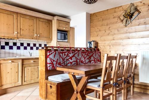 une cuisine avec une table et des chaises en bois dans l'établissement Résidence Les Alpages de Chantel - maeva Home - Appartement 4 pièces 8 personnes Sélection MAE-3804, à Bourg-Saint-Maurice