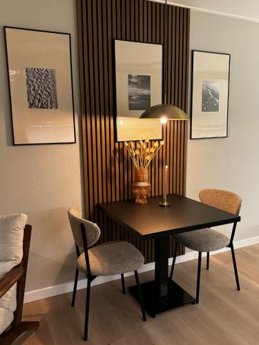 een eetkamer met een zwarte tafel en stoelen bij Studio 43 in Hollum