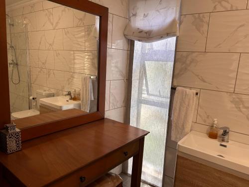 a bathroom with a mirror and a sink at Katlego in Bloemfontein