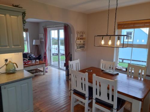 uma cozinha e sala de jantar com mesa e cadeiras em House Overlooking Ballinskelligs Bay em Waterville