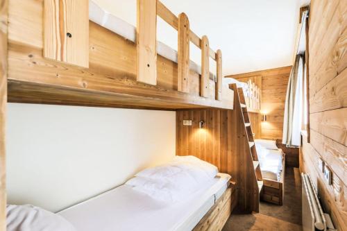 a bedroom with two bunk beds and a ladder at Résidence Les Chalets du Forum - maeva Home - Appartement 2 pièces 6 person 30 in Courchevel