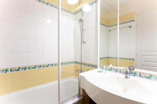 une salle de bain avec une baignoire, un lavabo et un miroir dans l'établissement Résidence Le Thabor - maeva Home - Duplex 3 pièces 7 personnes - Sélection MAE-5673, à Le Désert