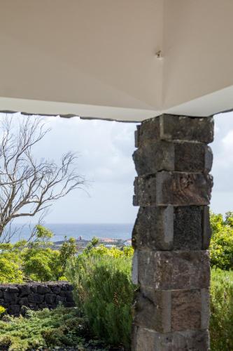 a view of the ocean from a stone pillar at Villa 4 Seasons in São Roque do Pico