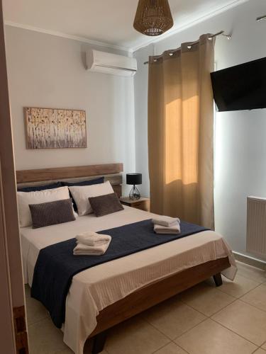 a bedroom with a large bed with two towels on it at La casa di Elen4 in Platy