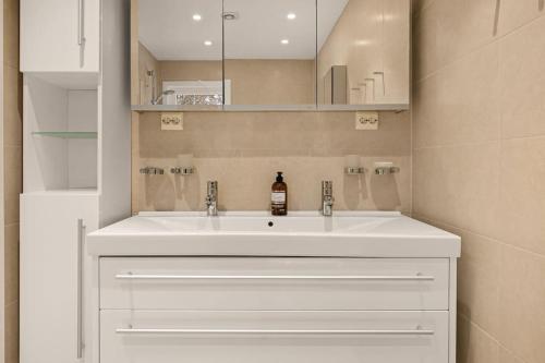 a bathroom with a white sink and a mirror at 141sqm for Family I Free Parking I Bathtub in Oslo