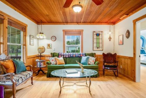 a living room with a green couch and a table at 118 - The Willow Tree Bungalow in Fall City