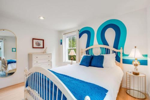 a blue and white bedroom with a bed and a mirror at 118 - The Willow Tree Bungalow in Fall City