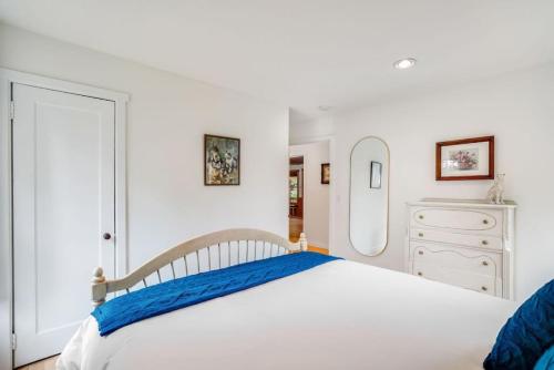 a white bedroom with a large bed and a mirror at 118 - The Willow Tree Bungalow in Fall City