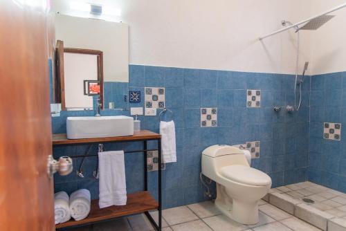 a bathroom with a toilet and a sink and a mirror at Casa Dei Girasoli in Cabo San Lucas