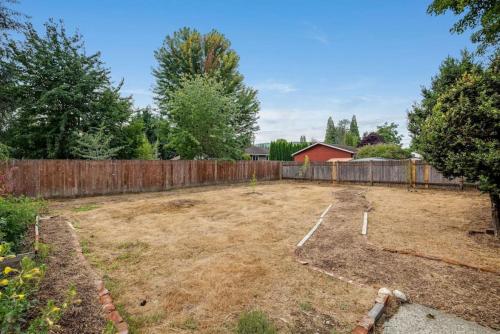 an empty backyard with a fence and a yard at 118 - The Willow Tree Bungalow in Fall City