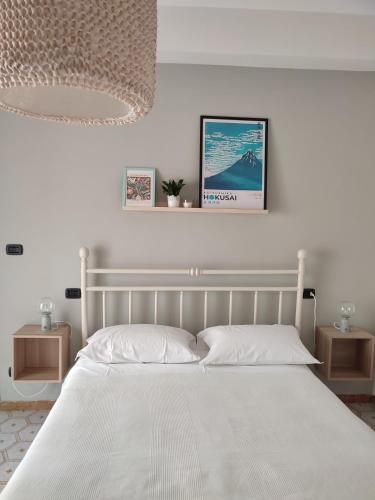a white bedroom with a large bed with white sheets at TERRA DI SUD Matera - free parking in Matera