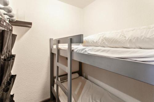 a bunk bed with white sheets on it in a room at Studio 4 personnes avec terrasse vue montagne à Vars 103282 in Vars