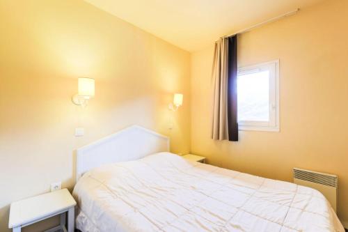 a bedroom with a white bed and a window at Résidence Le Thabor - maeva Home - Appartement 2 pièces 5 personnes Confort 81 in Le Désert