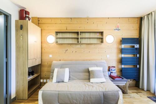 une chambre avec un lit et un mur en bois dans l'établissement Résidence Le Quartz - maeva Home - Appartement 2 pièces 5 personnes - Sélection MAE-6877, à La Plagne Tarentaise