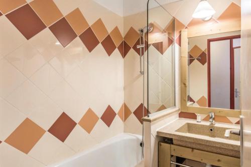 une salle de bain avec une baignoire, un lavabo et un miroir dans l'établissement Résidence Les Fontaines Blanches - maeva Home - Appartement 2 pièces 4 personnes - Confort MAE-7290, à Morzine