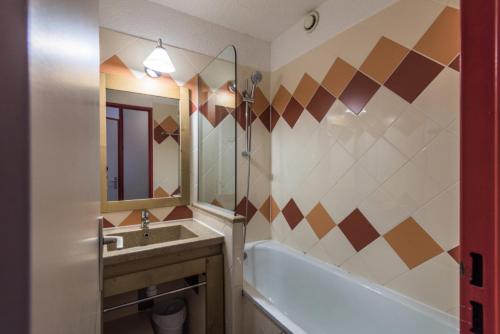 une salle de bain avec un lavabo, une baignoire et un miroir dans l'établissement Résidence Les Fontaines Blanches - maeva Home - Appartement 2 pièces 5 personnes Confort MAE-7291, à Avoriaz