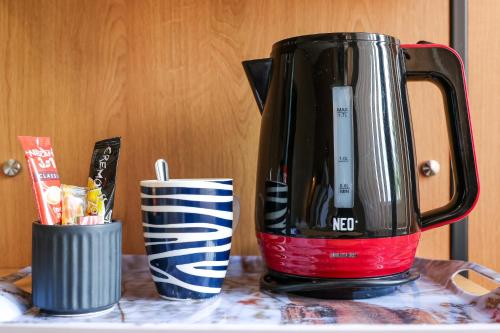 a black coffee pot sitting on a counter with a cup at Family Hotel Gotse Delchev in Gotse Delchev