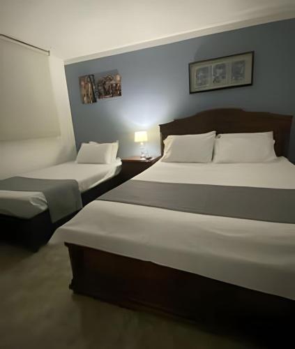a hotel room with two beds in a room at Hotel Boutique Casa Magaly in Bogotá