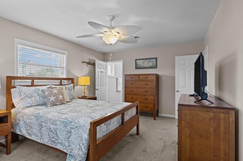 a bedroom with a bed and a flat screen tv at Colorful Emerald Isle Home Just Steps to Beach! in Emerald Isle