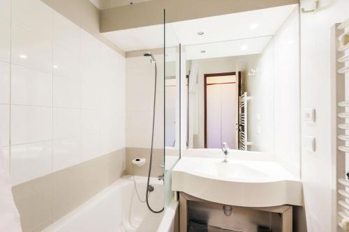 a white bathroom with a sink and a shower at Résidence Le Mont Soleil - maeva Home - Appartement 2 pièces 5 personnes Co 02 in Mâcot La Plagne
