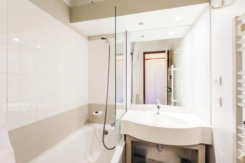 une salle de bain blanche avec un lavabo et une douche dans l'établissement Résidence Le Mont Soleil - maeva Home - Appartement 2 pièces 5 personnes - Sélection MAE-0302, à Mâcot La Plagne