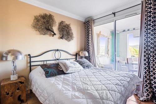 une chambre avec un lit et une grande fenêtre dans l'établissement Les Bastides aux Restanques du Golfe de St Tropez - maeva Home - Bastide 3 pièces 6 personnes vue mer - Prestige - Super Home MAE-0266, à Grimaud
