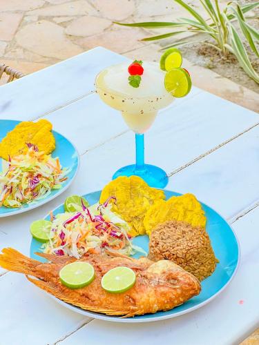 a table with two plates of food and a drink at Hotel Palma Grande by Stanza in Coveñas